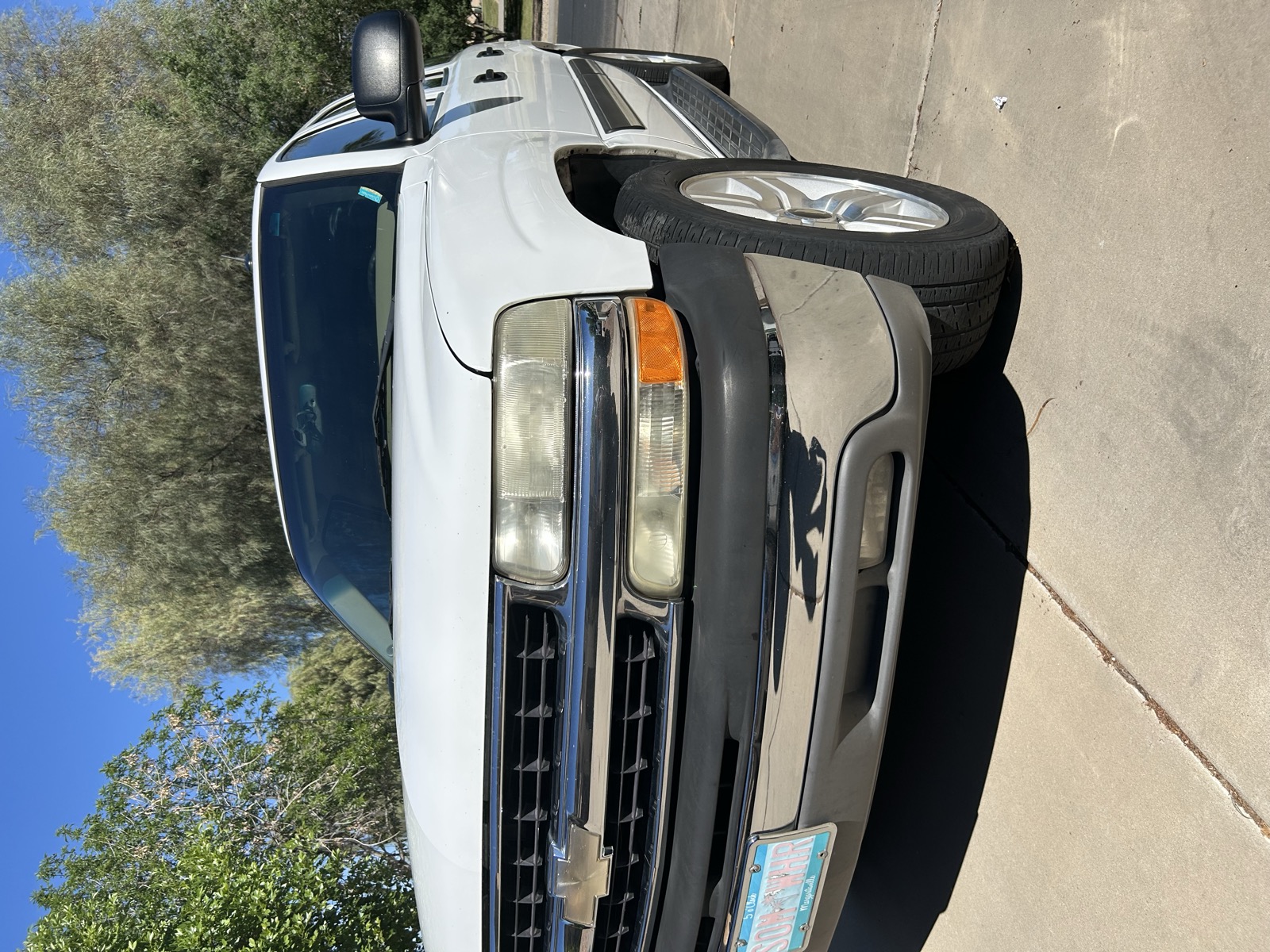 Freshly detailed white Chevy Tahoe, driver side exterior view