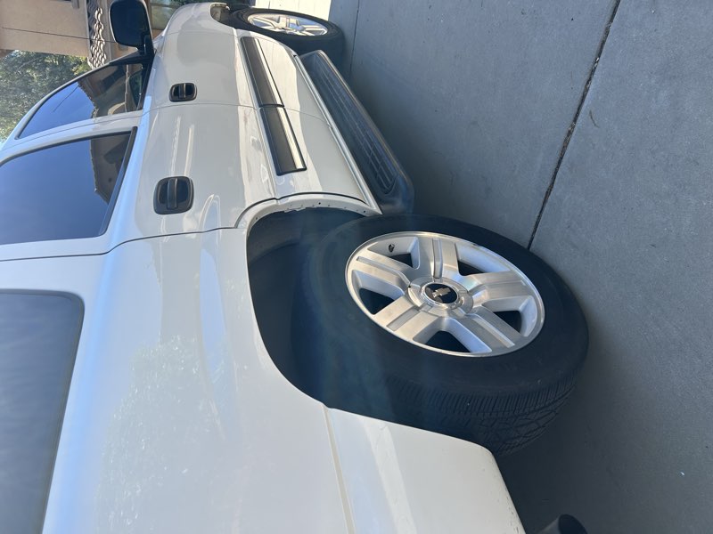 Detailed white Chevy Tahoe, rear wheel and side exterior view